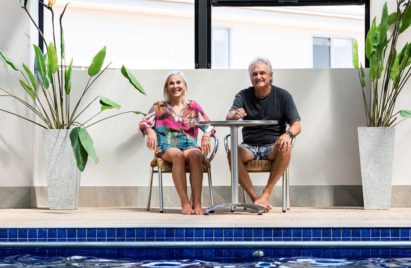 Retired couple enjoying the view from a swimming pool