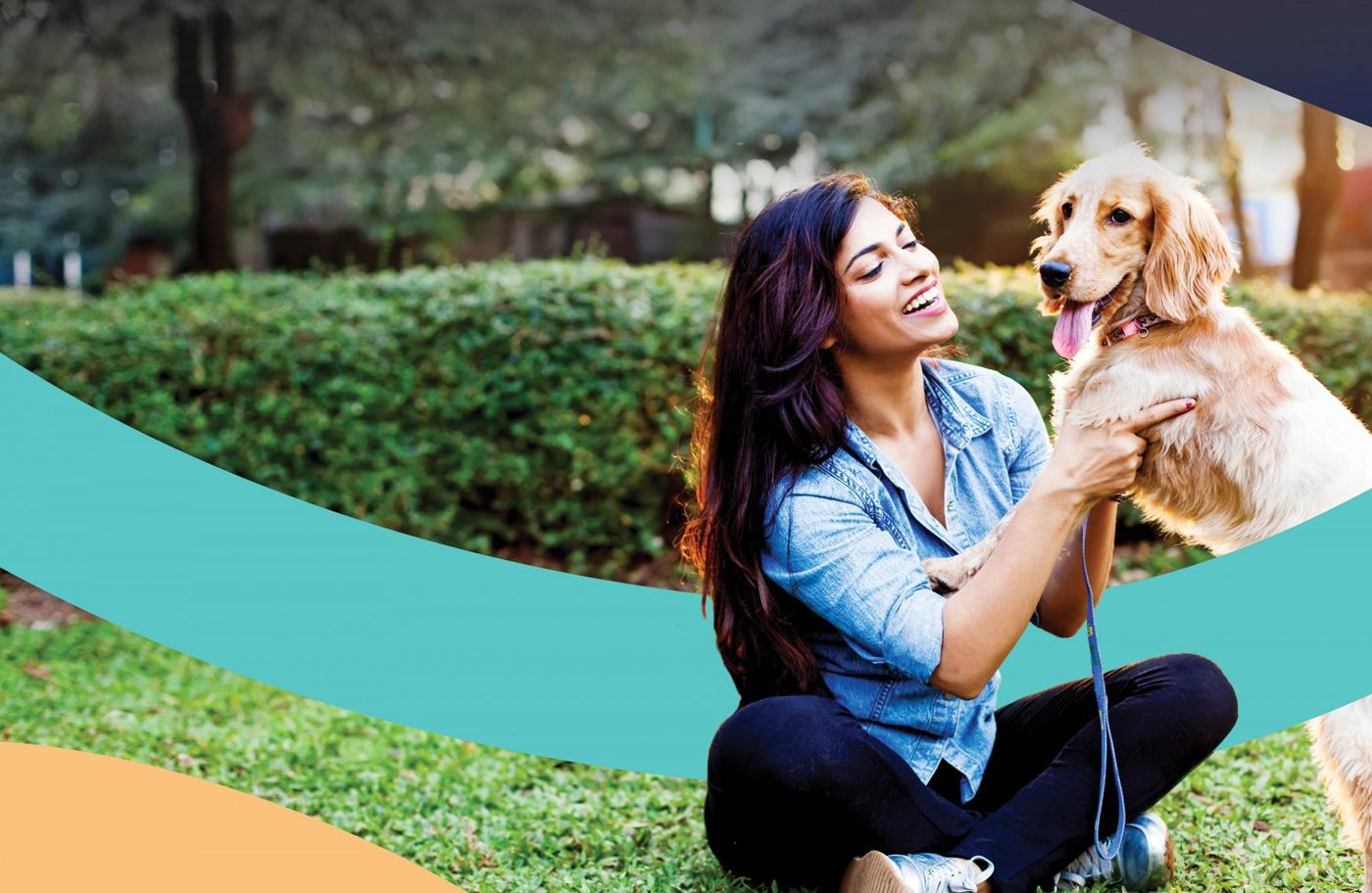 Lady happily planing with a dog at a park